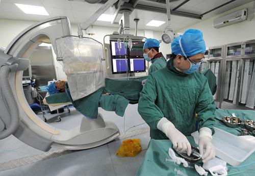 河南省人民医院的医护人员在第5导管室里穿上铅衣进行工作(5月8日摄)。新华社记者 赵鹏 摄